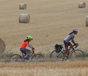 Ella, Hannah and Hannah pass  straw bales near Assesse