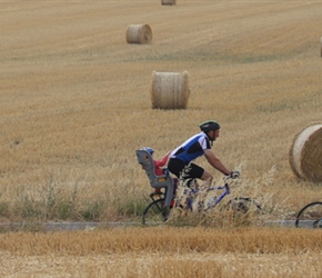 Rachel, Trevor and Ella pass straw bales near Assesse