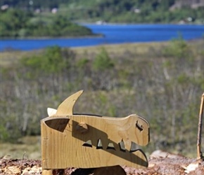 On a pile of logs, lay a carved wooden Dragons head. Anoya, Norway