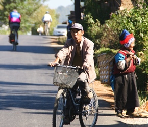 Emrys passes a cyclist and an old lady in local dress