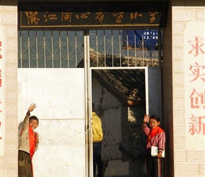 Chinese school children welcome their classmates at the start of the day