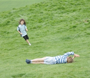 Lucy with Kate rolling down the hill at Glastonbury Tor