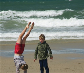 Jacob checks out Alice's handstand on Anse Beach