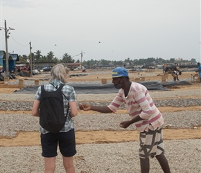 We were picked up by an enterprising guide who took us about the place. He seemed harmles enough but was described as a 'bad man' by several fishermen when we reached the market itself. Here he's showing Sharon the fish and trying to get her to taste